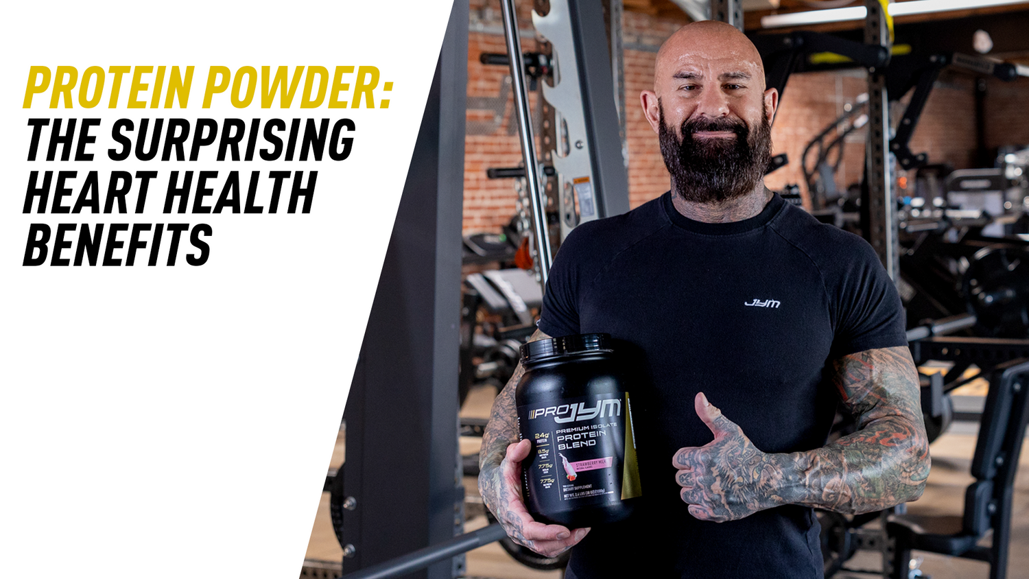 Protein Powder: The Surprising Heart Health Benefits — man with beard holds Pro JYM Strawberry Milk tub beside squat rack, thumbs up.