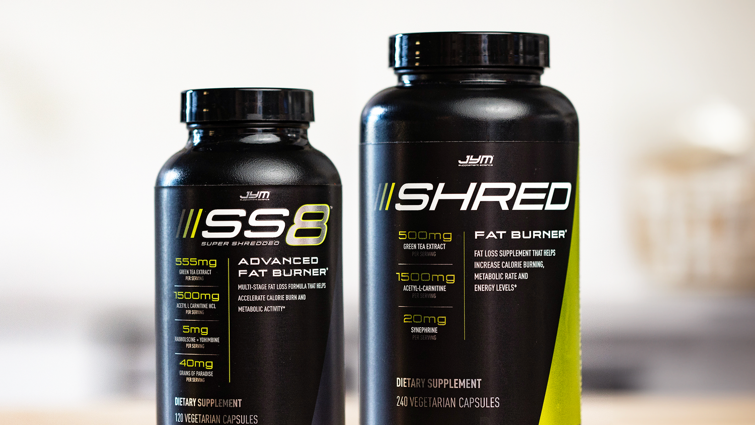 Black JYM SS8 and Shred fat burner bottles side by side on wood surface, labels facing forward, from "Get Shredded" article.
