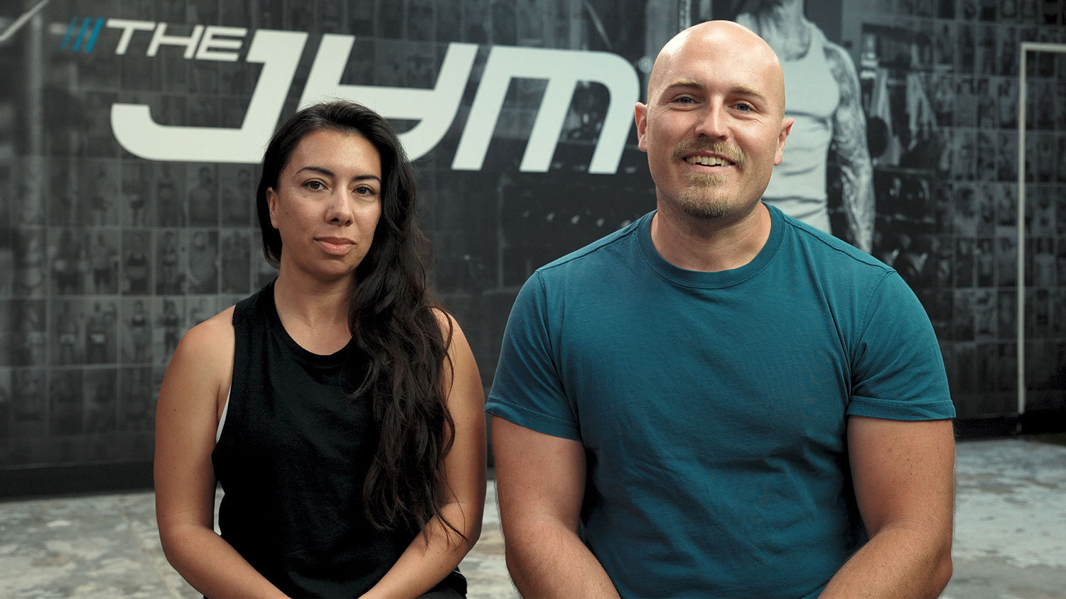 Peter and Cynthia sit smiling side by side before The JYM logo backdrop—Alpha JYM X Real Life Results: Peter and Cynthia.