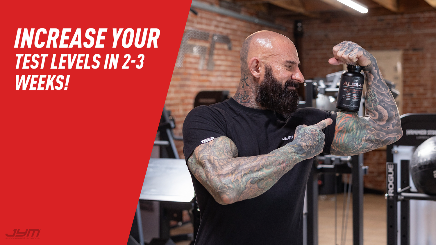 Bald tattooed man in black JYM tee points at Alpha JYM bottle held above his flexed arm in gym; banner: Increase Your Test Levels.