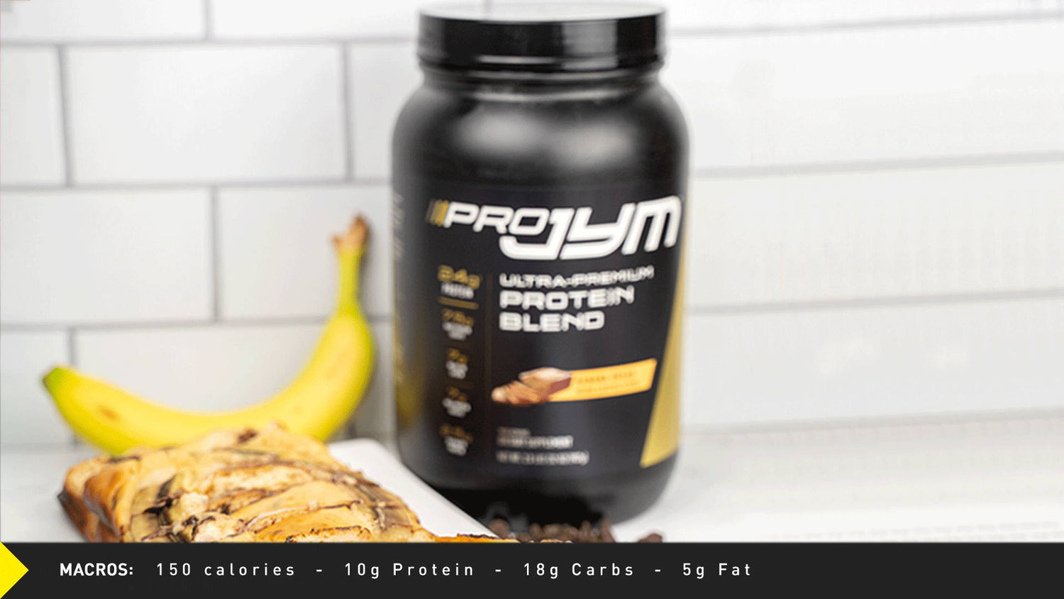 Pro JYM Banana Bread Recipe: protein tub on white subway tile counter with ripe banana and sliced chocolate banana loaf.