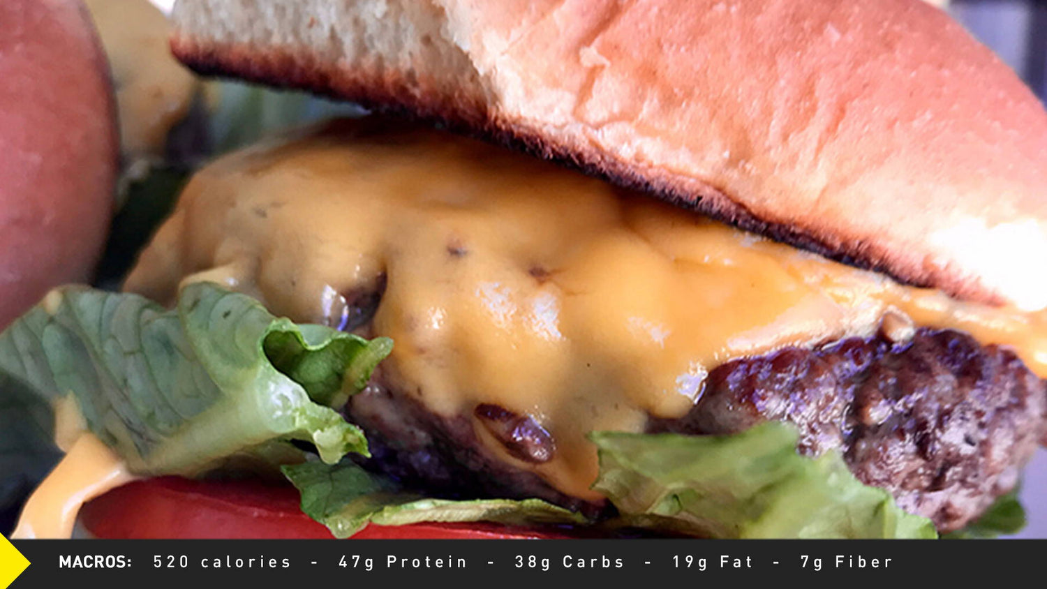 Close-up of Lean & Mean Cheeseburger with melted cheese, beef patty, lettuce, and tomato; macros: 520 cal, 47g protein.