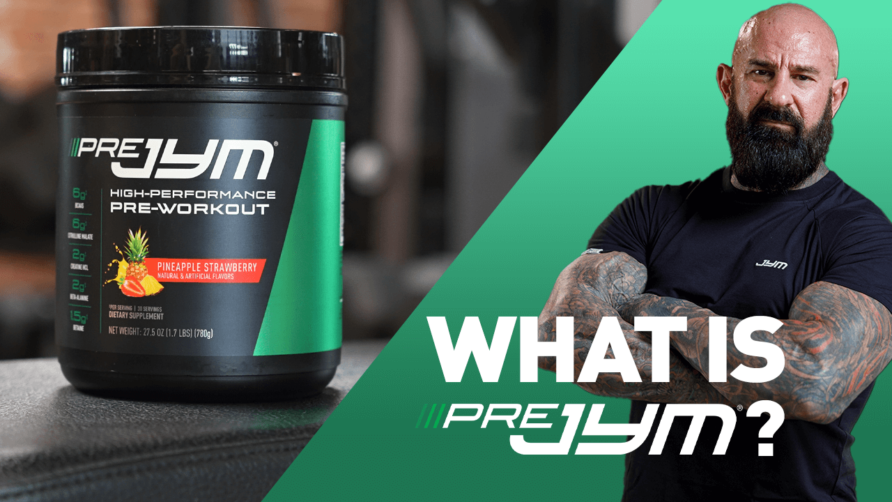 What is Pre JYM? article cover with Pineapple Strawberry Pre JYM tub beside bearded, tattooed man in JYM shirt, arms crossed.